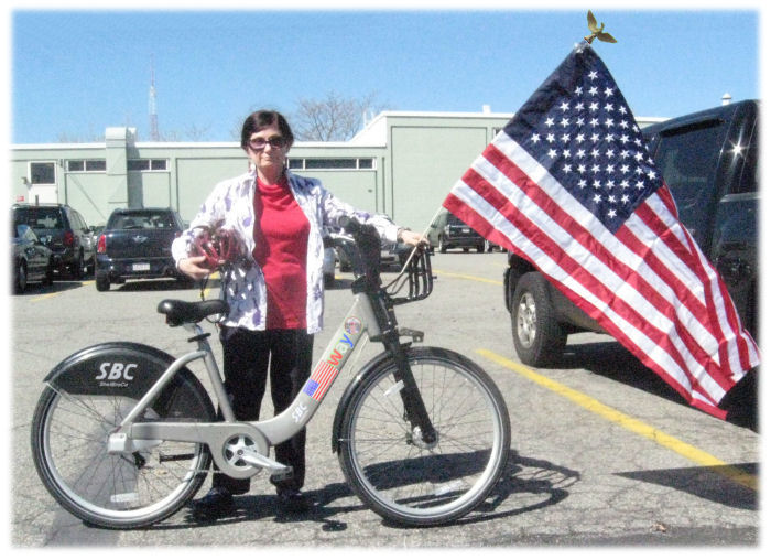 Harriet Fell with bicycle, helmet and flag